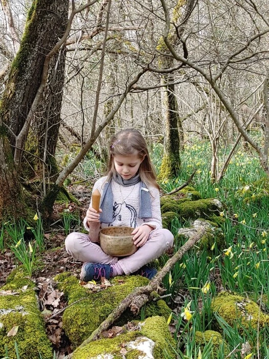Enfant et bol Une petite fille joue un bol chantant dans la forêt