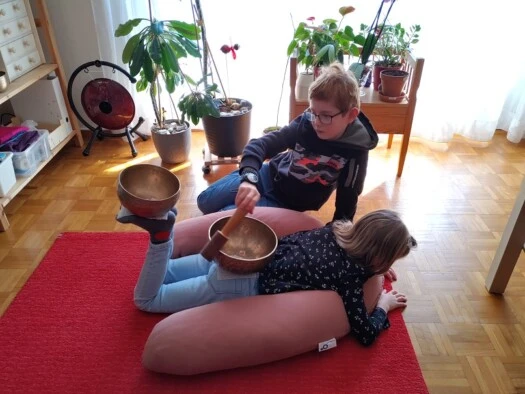 Enfants et bol chantants Un petit garçon joue du bol chantant pour sa soeur